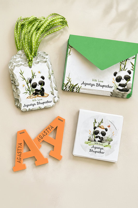 Panda-themed stationery items including cards, a tag, and a decorative item on a light background with green leaves.